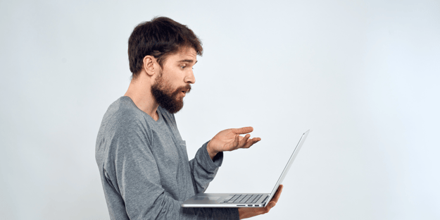 Man pointing at laptop in confusion