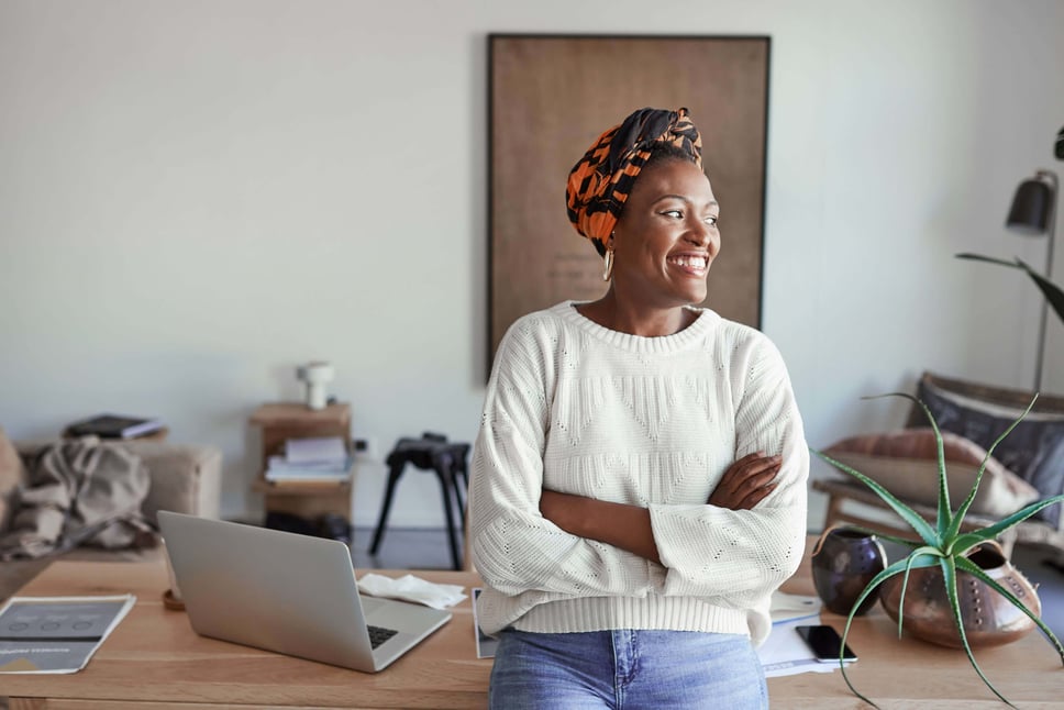 Professional standing confidently with arms crossed next to a laptop, representing secure IT disposal decisions